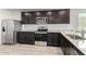 Modern kitchen features stainless steel appliances, gray cabinets and granite countertops at 8552 S 258Th Dr, Buckeye, AZ 85326