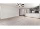 Bright living room features neutral carpet, ceiling fan and flows into the kitchen at 8552 S 258Th Dr, Buckeye, AZ 85326