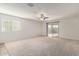 Bright, airy living room with neutral carpet and a sliding glass door to patio at 8552 S 258Th Dr, Buckeye, AZ 85326