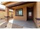 Cozy covered front porch featuring stone pillars and decorative trim around the window and front door at 8552 S 258Th Dr, Buckeye, AZ 85326