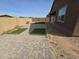 A fenced backyard features a paver patio area and small grass patches. Minimalist backyard design at , Maricopa, AZ 85138