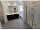 Bright bathroom featuring a large mirror, double vanity, soaking tub, and glass-enclosed shower at , Maricopa, AZ 85138