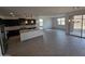 Bright open floor plan with a kitchen island, granite counters, and light-colored floors at , Maricopa, AZ 85138