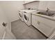 A spacious laundry room with a washer, dryer, tile floor, and sink at , Maricopa, AZ 85138