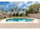 Scenic backyard with a beautiful pool, mature trees, and a well-maintained lawn for outdoor enjoyment at 1135 E Desert Holly Dr, San Tan Valley, AZ 85143