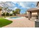 Beautiful backyard with a sparkling pool, lush green grass, and a covered patio with outdoor seating at 1135 E Desert Holly Dr, San Tan Valley, AZ 85143