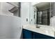 Bathroom with a blue vanity cabinet and large mirror that reflects the shower at 1135 E Desert Holly Dr, San Tan Valley, AZ 85143