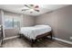 Cozy bedroom with a ceiling fan, wood floors, and a bright window with a view at 1135 E Desert Holly Dr, San Tan Valley, AZ 85143