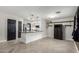 Spacious living room featuring herringbone floors, kitchen island, and modern lighting fixtures at 1135 E Desert Holly Dr, San Tan Valley, AZ 85143