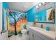 Bright bathroom with white tiling, blue accent wall, and tree-themed shower curtain at 1180 E Belmont Ave, Phoenix, AZ 85020