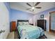 Bedroom features a ceiling fan, a door to the outside, and a large bed with decorative pillows at 1180 E Belmont Ave, Phoenix, AZ 85020