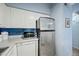Bright kitchen featuring stainless steel refrigerator, microwave, and white cabinets with blue tile backsplash at 1180 E Belmont Ave, Phoenix, AZ 85020