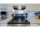 Kitchen featuring a black cooktop and oven beneath an exhaust fan with white cabinets at 1180 E Belmont Ave, Phoenix, AZ 85020