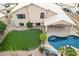 Aerial view showcases the backyard oasis with a sparkling pool, lush landscaping, and grassy yard at 1321 N Bronco Ct, Gilbert, AZ 85233