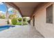 Covered patio overlooking the lush backyard with a well-manicured lawn and tropical trees at 1321 N Bronco Ct, Gilbert, AZ 85233
