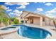 Beautiful backyard featuring a sparkling pool, covered patio, and lush green landscaping at 1321 N Bronco Ct, Gilbert, AZ 85233