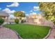 Lush backyard with artificial turf, mature trees, and well-manicured landscaping at 1321 N Bronco Ct, Gilbert, AZ 85233