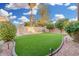 Expansive backyard featuring lush artificial turf, mature trees, and landscape lighting at 1321 N Bronco Ct, Gilbert, AZ 85233