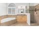 Bright bathroom features soaking tub and walk-in shower with decorative tiles at 1321 N Bronco Ct, Gilbert, AZ 85233