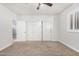 Bright bedroom with neutral carpet, fan, window with shutters and sliding closet doors at 1321 N Bronco Ct, Gilbert, AZ 85233
