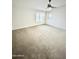 A spacious, carpeted bedroom that features a ceiling fan and a window at 1321 N Bronco Ct, Gilbert, AZ 85233