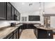 Contemporary kitchen featuring dark cabinets, granite countertops, stainless steel appliances, and an island with bar seating at 1321 N Bronco Ct, Gilbert, AZ 85233