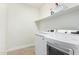 Well-lit laundry room with white washer and dryer, and storage shelf at 1321 N Bronco Ct, Gilbert, AZ 85233