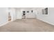 Open living room with neutral carpet, white walls, and staircase, providing seamless access to other areas of the house at 1321 N Bronco Ct, Gilbert, AZ 85233