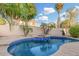 Inviting pool with a spa, waterfall feature, and well-manicured desert landscaping at 1321 N Bronco Ct, Gilbert, AZ 85233