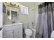 Clean bathroom with white vanity, toilet, and a shower-tub combination with decorative shower curtain at 1409 E Apollo Rd, Phoenix, AZ 85042