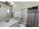 Well-lit bathroom with a single sink vanity and a shower-tub combo with decorative curtain at 1409 E Apollo Rd, Phoenix, AZ 85042