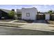 Side view of single story home with tile roof, desert landscaping, and private front patio area at 1409 E Apollo Rd, Phoenix, AZ 85042