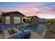 A gorgeous backyard features a shimmering pool, a fire pit, and comfortable lounge seating under a stunning sunset sky at 1432 E Pedro Rd, Phoenix, AZ 85042