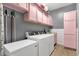 A laundry room with pink cabinets over the washer and dryer at 1432 E Pedro Rd, Phoenix, AZ 85042