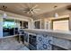 Outdoor bar with built-in grill, beverage center, and seating area under a covered patio at 1432 E Pedro Rd, Phoenix, AZ 85042