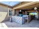 Inviting outdoor kitchen featuring bar seating, grilling area, a heater, and a ceiling fan at 1432 E Pedro Rd, Phoenix, AZ 85042