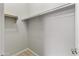 Simple walk-in closet with one rod and a light wood-look tile floor at 1432 E Pedro Rd, Phoenix, AZ 85042