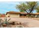 Single-story home with desert landscaping, mature tree, and attached two-car garage at 14418 N San Carlos Dr, Fountain Hills, AZ 85268