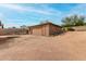 A detached one-car garage with wood siding sits in an expansive gravel driveway at 14418 N San Carlos Dr, Fountain Hills, AZ 85268