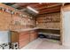 A garage interior features a workbench with storage shelves and red brick flooring at 14418 N San Carlos Dr, Fountain Hills, AZ 85268