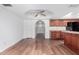 Spacious room with hardwood floors, leading to an arched entrance and kitchen featuring wood cabinets at 14418 N San Carlos Dr, Fountain Hills, AZ 85268