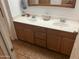 This bathroom has double sinks, wood cabinets, and tile floors at 1495 N Casa Grande Ave, Casa Grande, AZ 85122