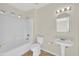 Clean bathroom with a tub/shower combination, neutral tile, and a pedestal sink at 15864 W Clearwater Way, Surprise, AZ 85374