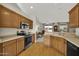 Well-lit kitchen with light-colored countertops and wooden cabinets that transitions into a living area at 15864 W Clearwater Way, Surprise, AZ 85374