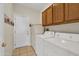 Functional laundry room with washer, dryer, storage cabinets, and exterior door at 15864 W Clearwater Way, Surprise, AZ 85374