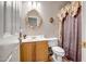 Bathroom featuring a modern sink, wood cabinets, a decorative mirror, and a toilet at 16875 W Manchester Dr, Surprise, AZ 85374