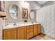 Bathroom featuring double sinks with a modern countertop, cabinets, and decorative mirrors at 16875 W Manchester Dr, Surprise, AZ 85374