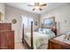 Bedroom featuring a wood frame bed, ceiling fan, window shutters, and matching furniture at 16875 W Manchester Dr, Surprise, AZ 85374