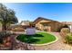 Landscaped backyard featuring artificial turf, gravel and a sitting area with a grill at 19863 N Emmerson Dr, Maricopa, AZ 85138