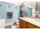 A well-lit bathroom features blue and gray walls, wooden cabinets, and a large mirror at 19863 N Emmerson Dr, Maricopa, AZ 85138